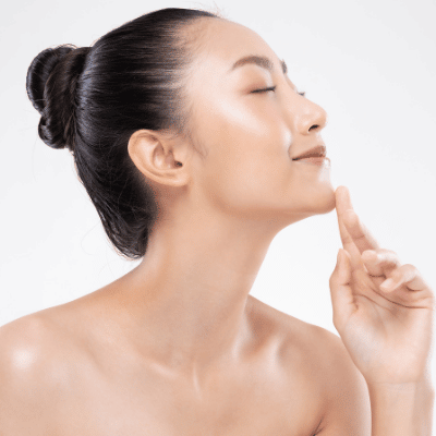 beautiful glowy asian woman looking right pointing to chin